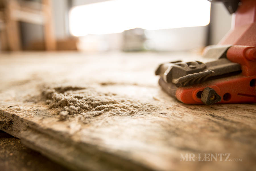 sanding a wood floor in workshop