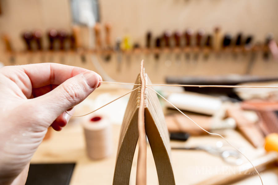pulling a needle through leather