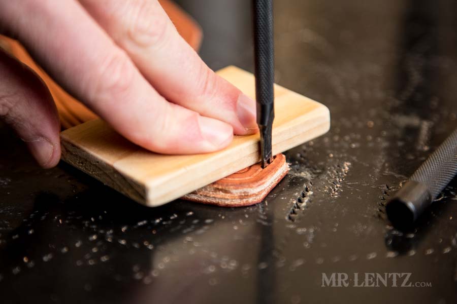 using a wood block while punching holes in leather with diamond chisel
