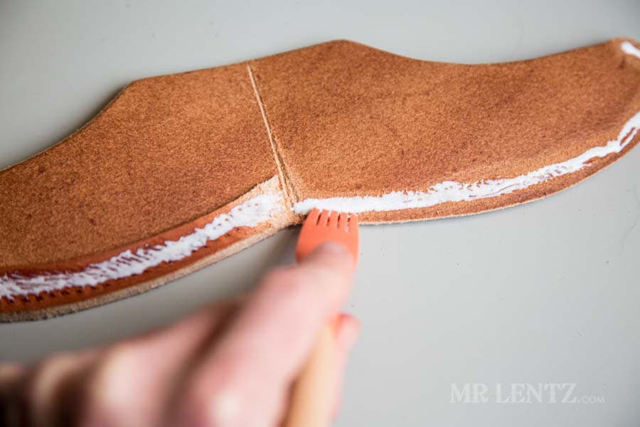 spreading glue on the welt of an axe sheath