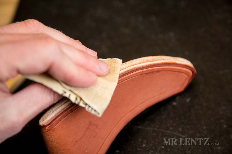 sanding the edge of an axe sheath