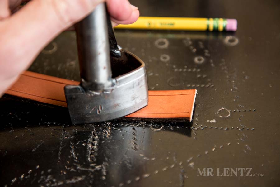 using a belt end tip cutter on retaining strap for axe sheath