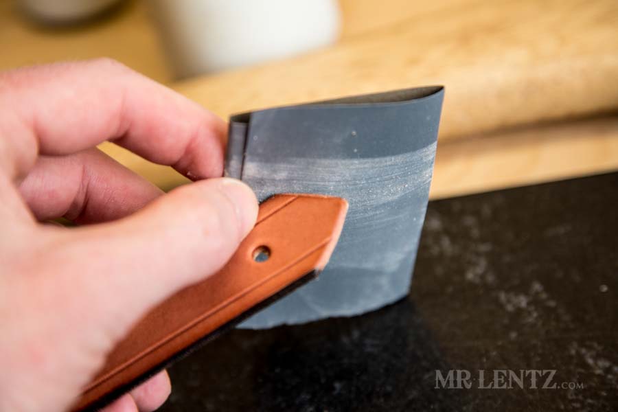 sanding the tip on strap for axe sheath