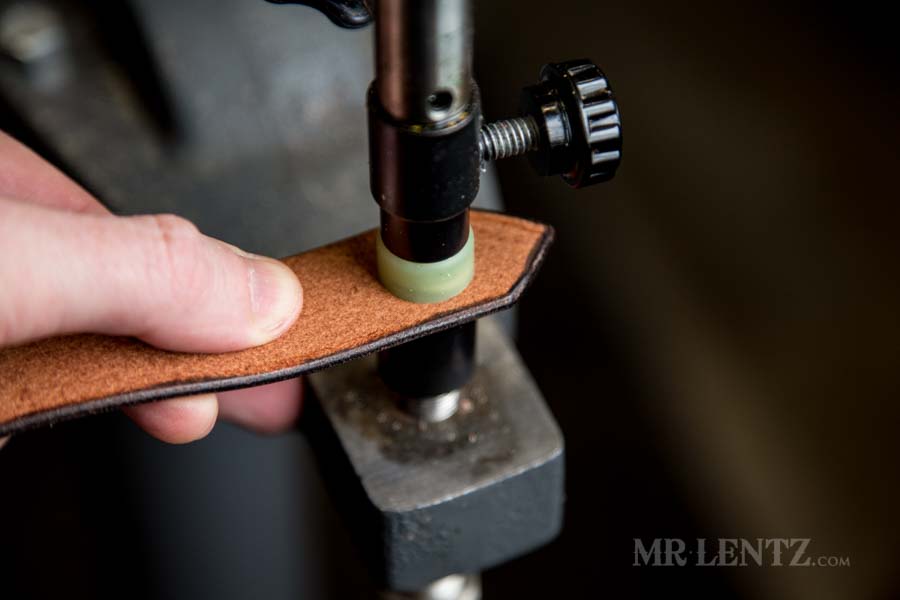 pressing the button on the strap for axe sheath