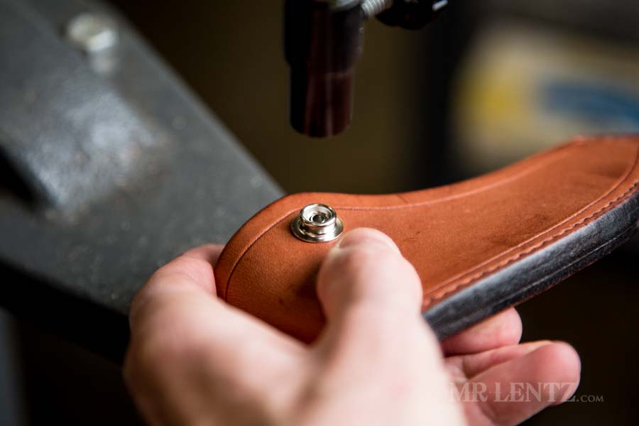 placing the stud on the axe sheath body