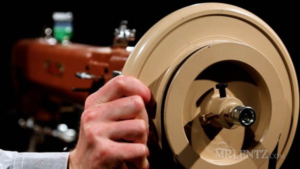turning the handwheel on a leather sewing machine