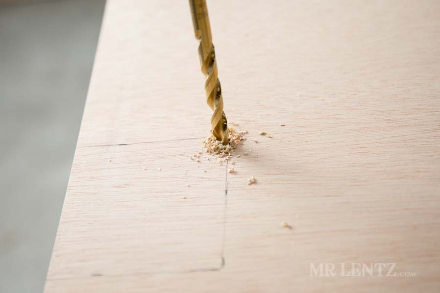 drilling holes into plywood for cutout