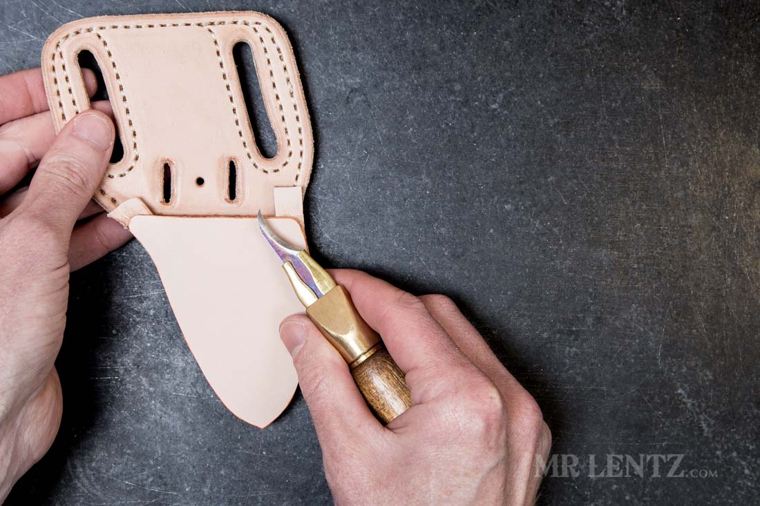 cutting off the excess leather in a knife sheath