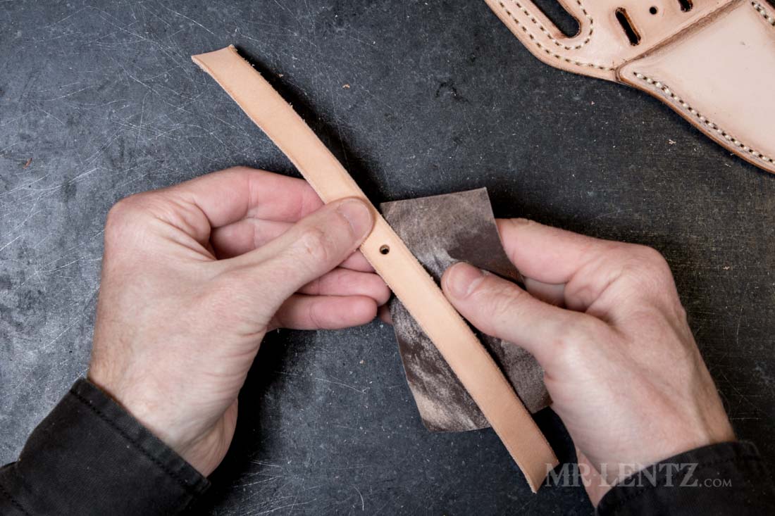 punching the hole and sanding the edge of the retaining strap