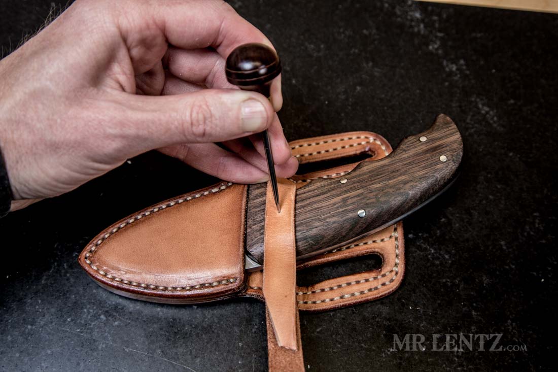 using a marking awl to place the snap location on retaining strap